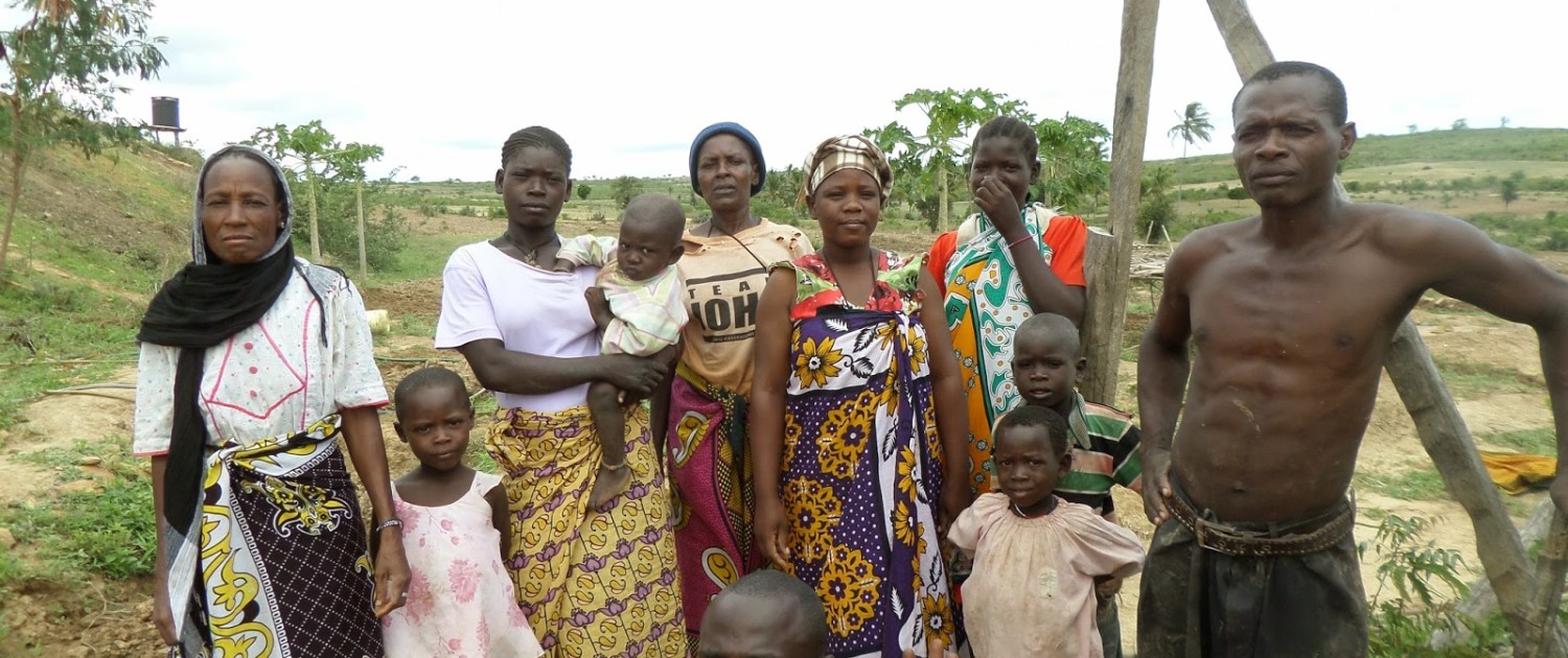 Tsuma (far right) and a group of villagers pose next to their community garden in Gona, Kenya. 